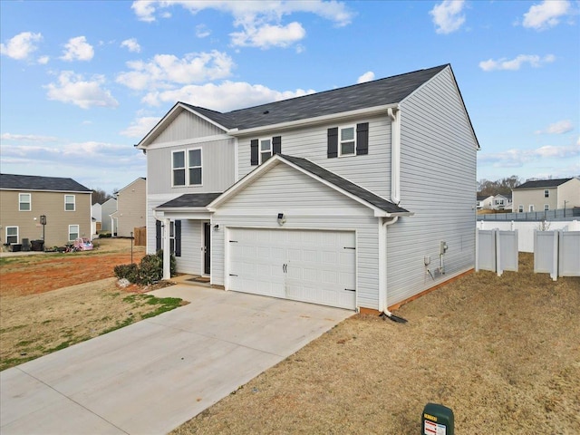 traditional-style house featuring an attached garage, fence, concrete driveway, a residential view, and a front yard