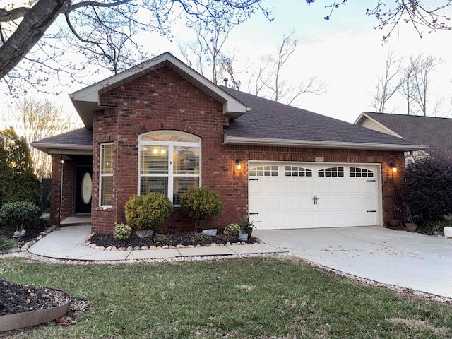 single story home featuring a garage, brick siding, a shingled roof, driveway, and a front lawn