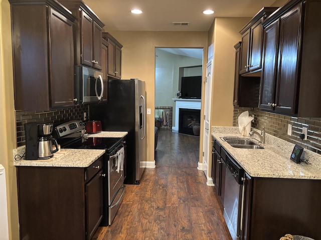 kitchen featuring dark brown cabinetry, visible vents, stainless steel appliances, and a sink