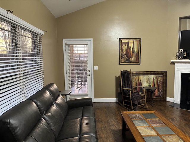 living room with a fireplace with flush hearth, lofted ceiling, dark wood-style flooring, and baseboards