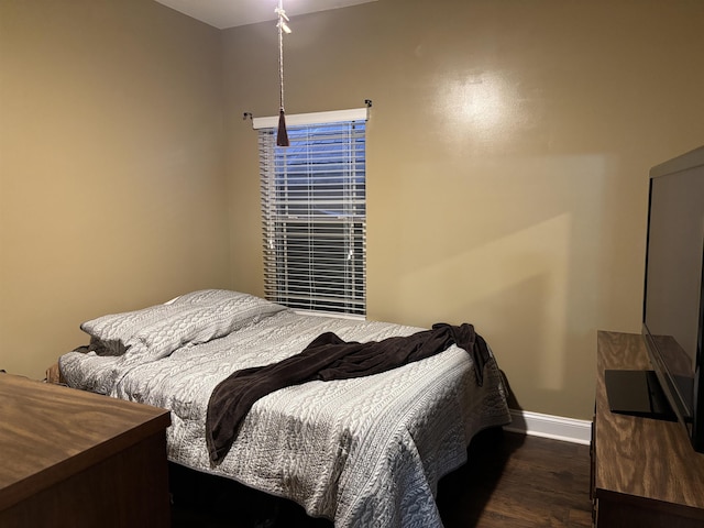 bedroom with baseboards and dark wood finished floors