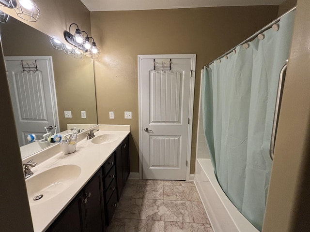 bathroom featuring shower / bath combination with curtain, marble finish floor, double vanity, and a sink