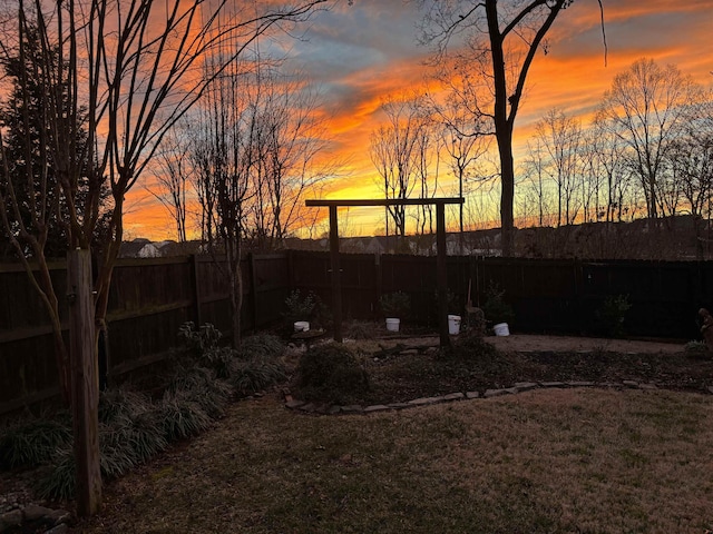 yard at dusk featuring fence