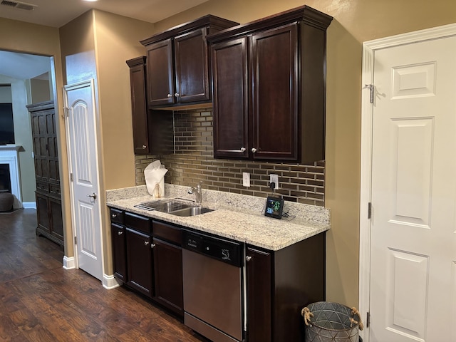 kitchen featuring dark brown cabinetry, dark wood-style flooring, a sink, dishwasher, and tasteful backsplash