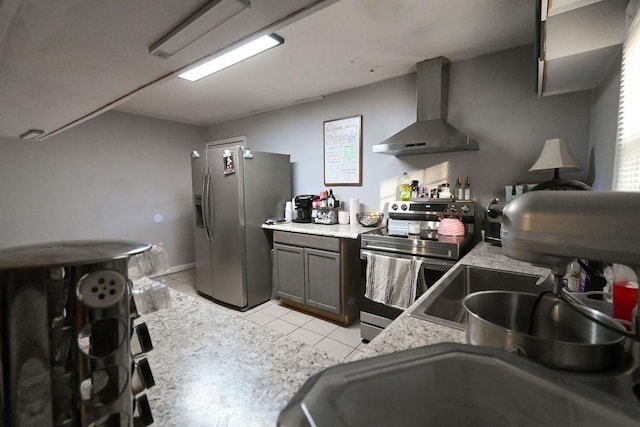 kitchen featuring light tile patterned floors, wall chimney exhaust hood, stainless steel appliances, and light countertops