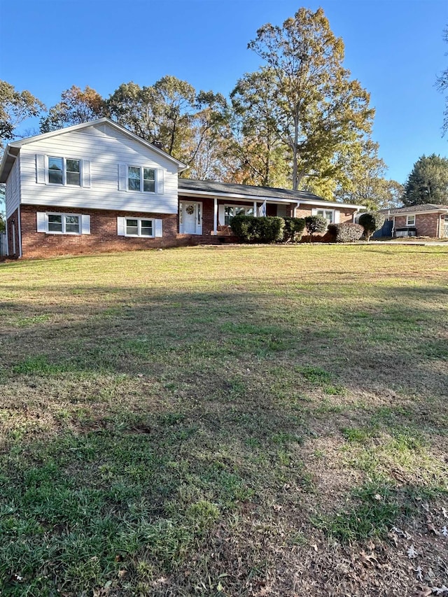 split level home featuring brick siding and a front yard