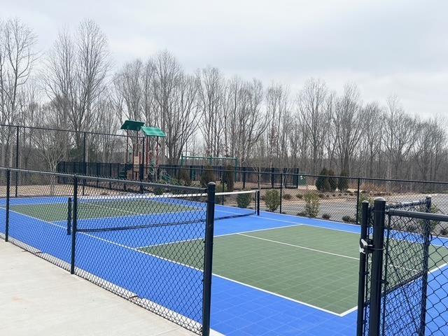 view of tennis court featuring fence