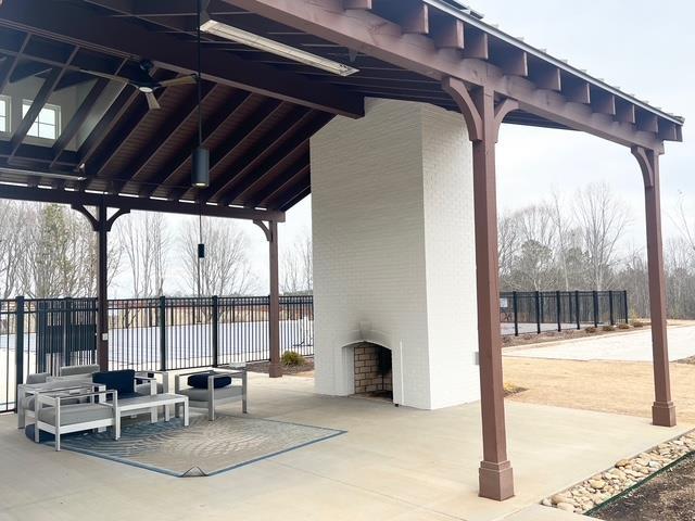 view of patio featuring a water view and fence