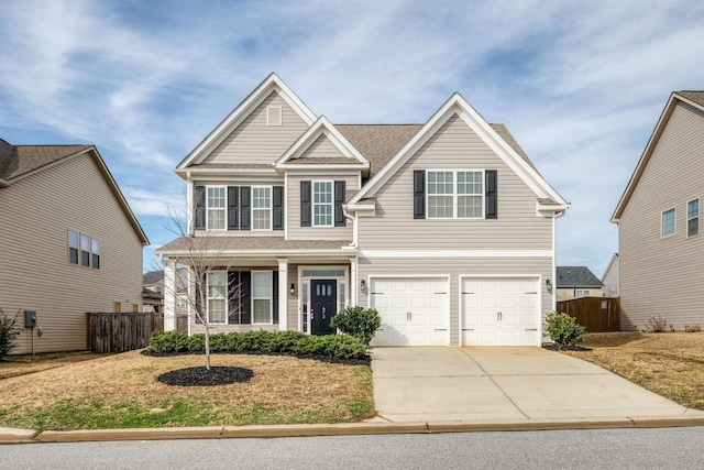 view of front of home featuring a garage, concrete driveway, a front yard, and fence