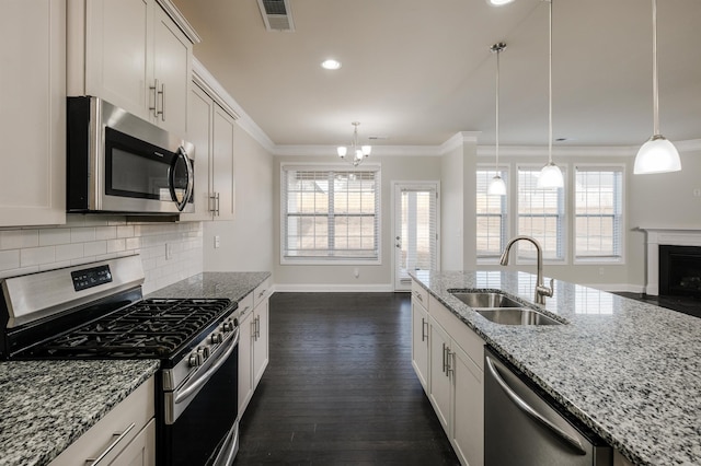 kitchen with tasteful backsplash, visible vents, crown molding, stainless steel appliances, and a sink