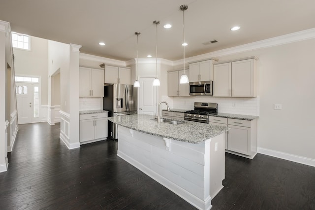 kitchen featuring visible vents, a kitchen island with sink, dark wood-style flooring, a sink, and stainless steel appliances