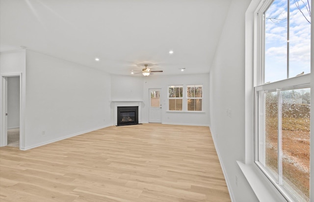 unfurnished living room featuring light wood-type flooring, a fireplace with flush hearth, ceiling fan, and recessed lighting