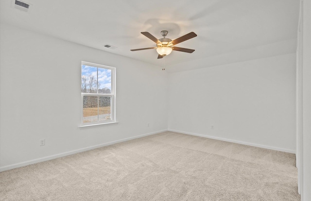 spare room with baseboards, visible vents, and light colored carpet