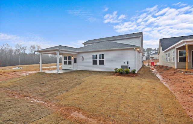 back of house with central AC, a lawn, and a patio area