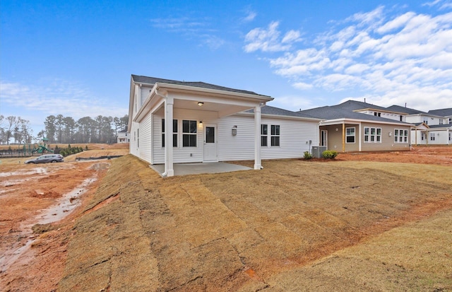 view of front facade with a patio area, cooling unit, and a front yard