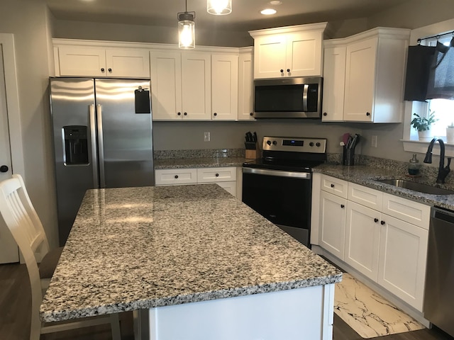 kitchen with appliances with stainless steel finishes, a center island, and a sink