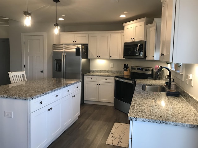 kitchen featuring white cabinetry, appliances with stainless steel finishes, a sink, and a center island