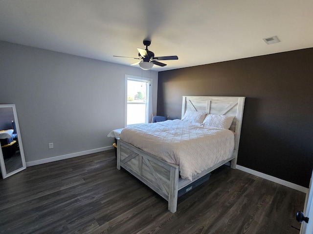 bedroom featuring a ceiling fan, visible vents, dark wood finished floors, and baseboards