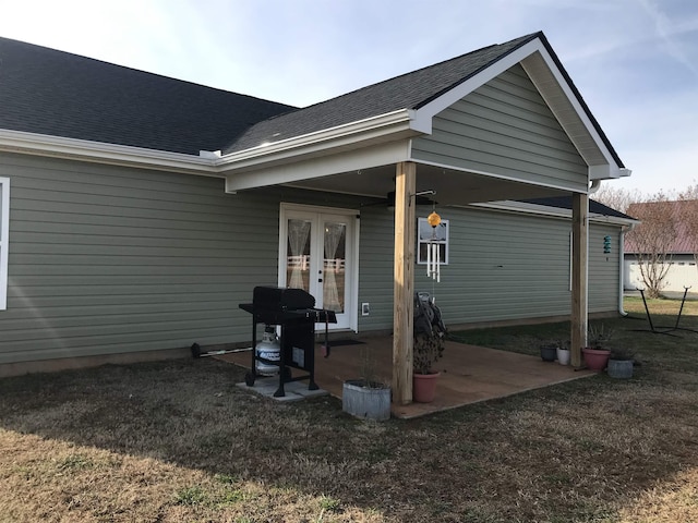 back of house featuring a patio, french doors, and roof with shingles