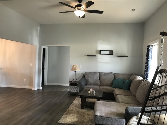 living room featuring baseboards, a ceiling fan, vaulted ceiling, and dark wood-style flooring