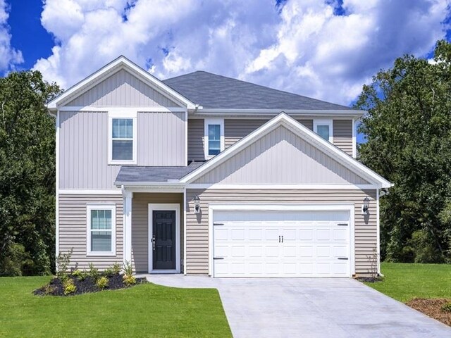 view of front of property featuring a front yard, driveway, and an attached garage