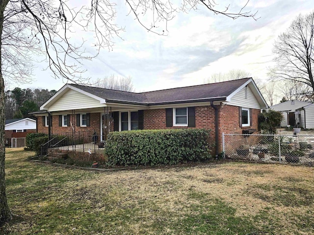 view of front of house with fence private yard, a front lawn, and brick siding