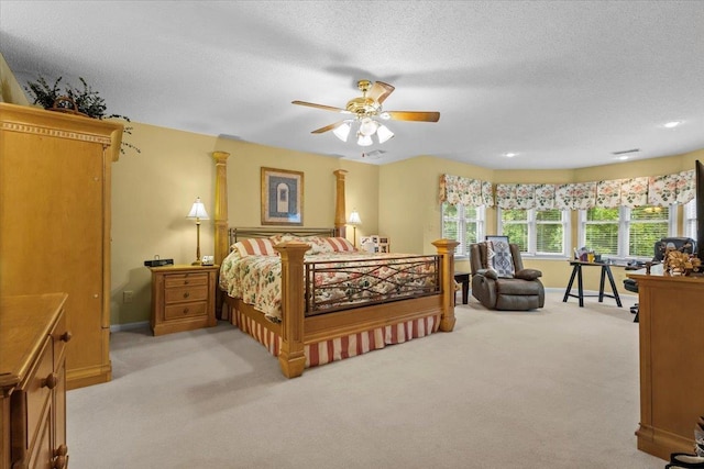 bedroom with a ceiling fan, light carpet, a textured ceiling, and baseboards