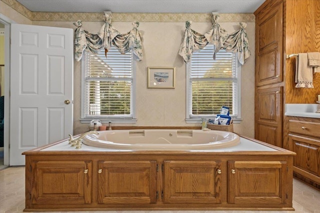 full bathroom featuring a garden tub, plenty of natural light, and a textured ceiling