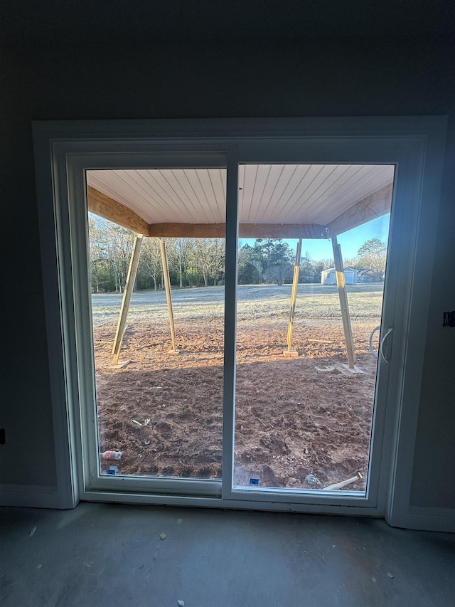 doorway to outside featuring concrete floors and a rural view