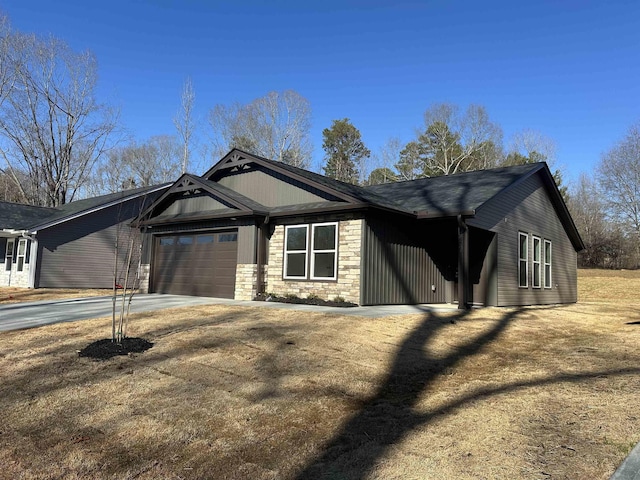 view of front facade featuring a garage, stone siding, and driveway