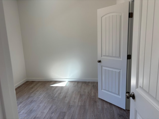 spare room with dark wood-style flooring and baseboards