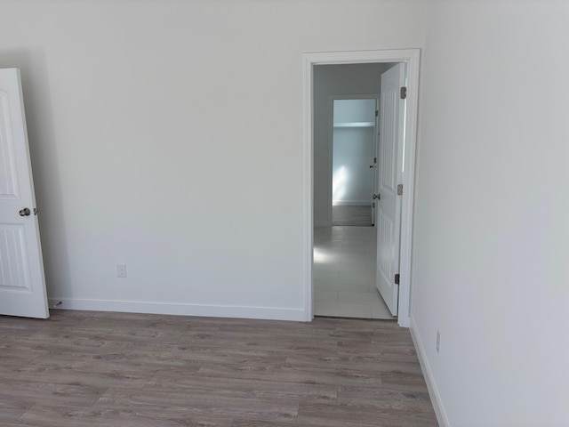 spare room with light wood finished floors and baseboards