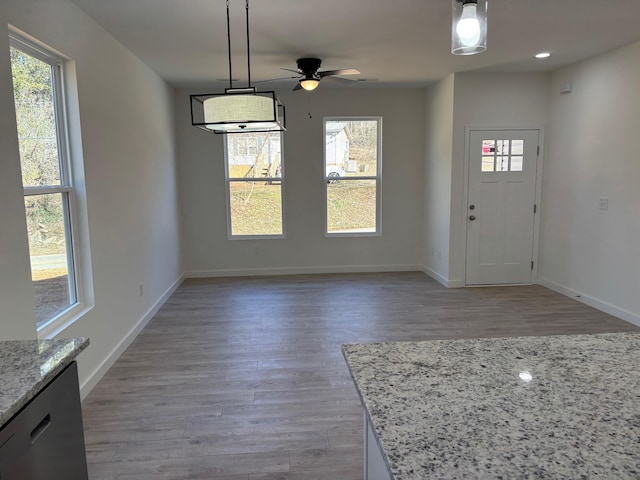 entryway with light wood-style floors, ceiling fan, and baseboards