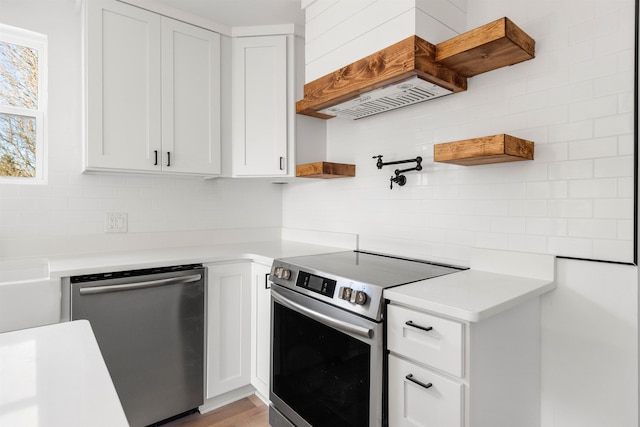 kitchen with stainless steel appliances, decorative backsplash, light countertops, and white cabinets