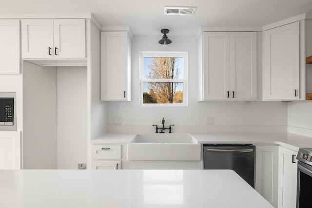 kitchen with white cabinets, light countertops, and dishwasher