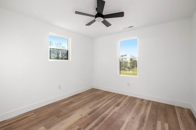 unfurnished room with light wood-style floors, visible vents, ceiling fan, and baseboards