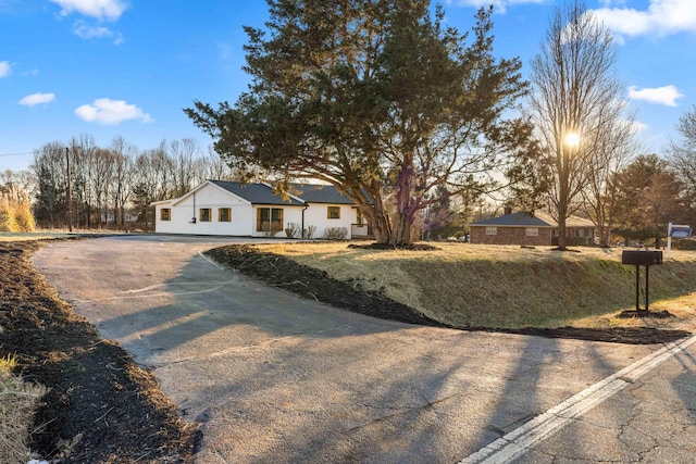 single story home featuring driveway and a front lawn