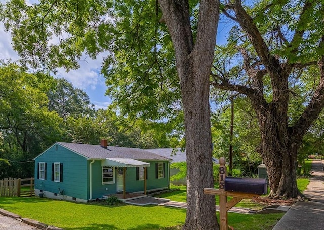 ranch-style house featuring a front yard, crawl space, fence, and a chimney