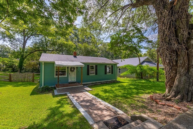 view of front of property with a front yard, fence, and a chimney