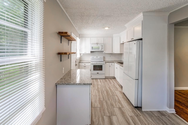 kitchen with white appliances, white cabinets, decorative backsplash, light stone counters, and open shelves