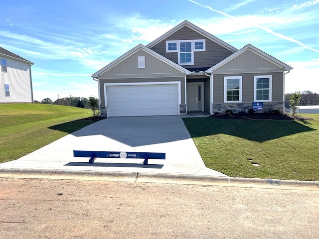 craftsman house featuring stone siding, an attached garage, concrete driveway, and a front lawn