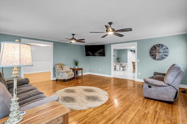 living area featuring a textured ceiling, ornamental molding, and wood finished floors