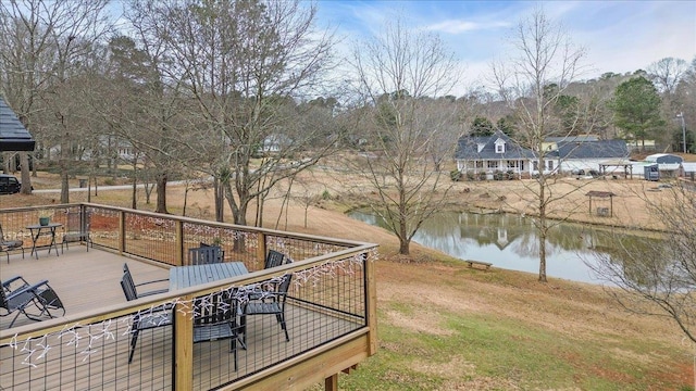 exterior space featuring outdoor dining area and a deck with water view