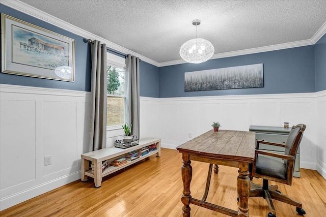 office featuring light wood-type flooring, crown molding, a textured ceiling, and wainscoting