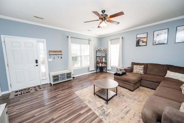 living area with baseboards, ornamental molding, and wood finished floors