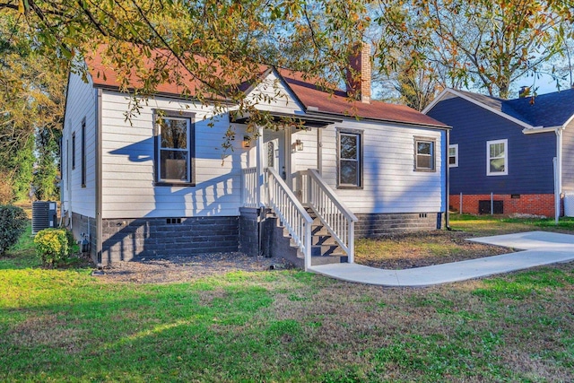 view of front of house featuring a front yard, crawl space, a chimney, and central AC unit