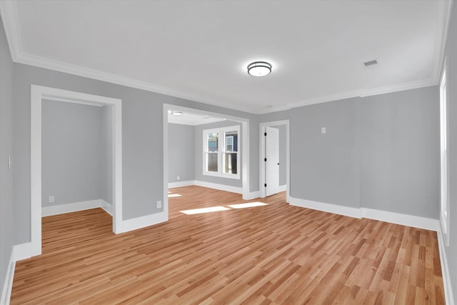 unfurnished room with baseboards, crown molding, visible vents, and light wood-style floors