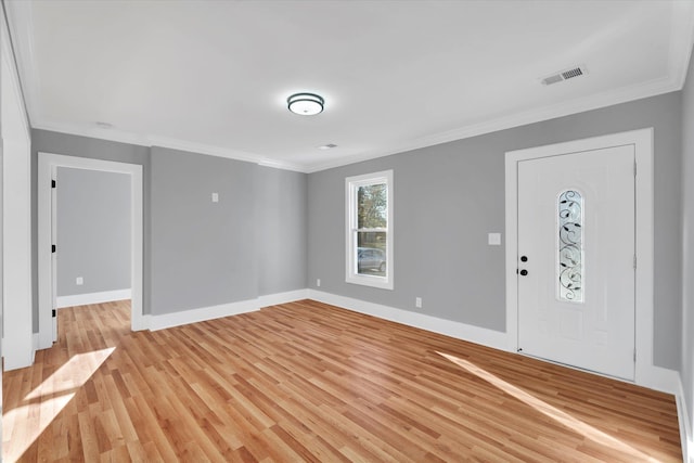 foyer featuring light wood-style floors, visible vents, ornamental molding, and baseboards