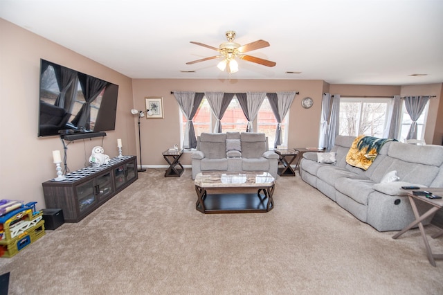 living room with a healthy amount of sunlight, a ceiling fan, visible vents, and light colored carpet