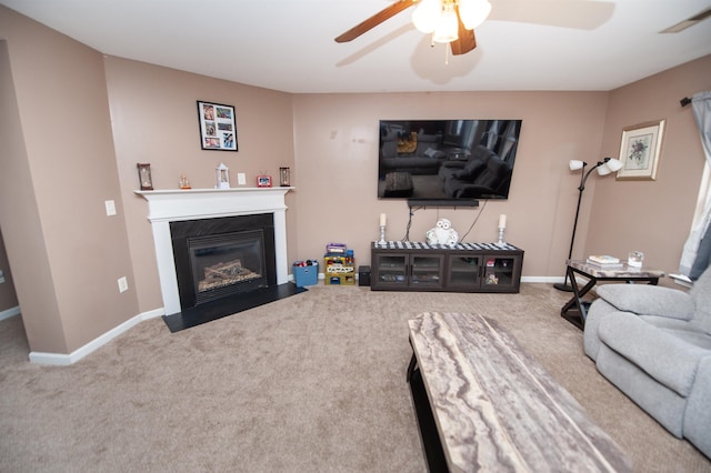 carpeted living area with ceiling fan, a fireplace with flush hearth, visible vents, and baseboards